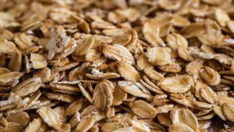 Rolled oats in a wooden spoon - whole grain for weight loss breakfast